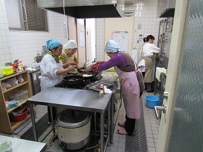 「厨房にて調理をされる中京西地区更生保護女性会の皆さん」
